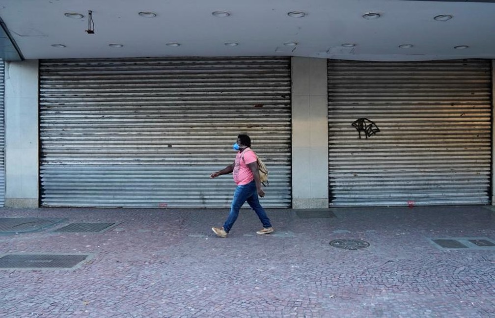 Mulher caminha no centro de Madureira, na Zona Norte do Rio, com comércio fechado durante a pandemia — Foto: Marcos Serra Lima/G1