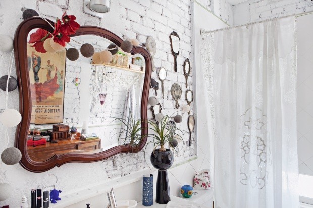No banheiro com tijolos originais, há coleção de espelhos antigos (Foto: Lufe Gomes / Editora Globo)