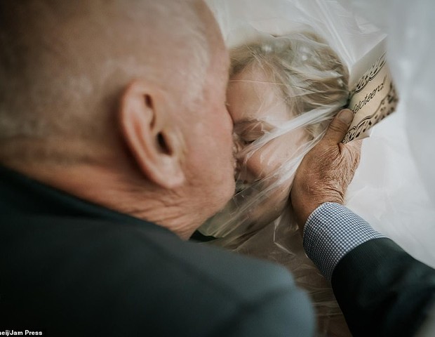 Momento em que um pai idoso beija sua futura filha na testa enquanto ela estava coberta por um filme plástico protetor, na Holanda (Foto: Tom Tomeij)