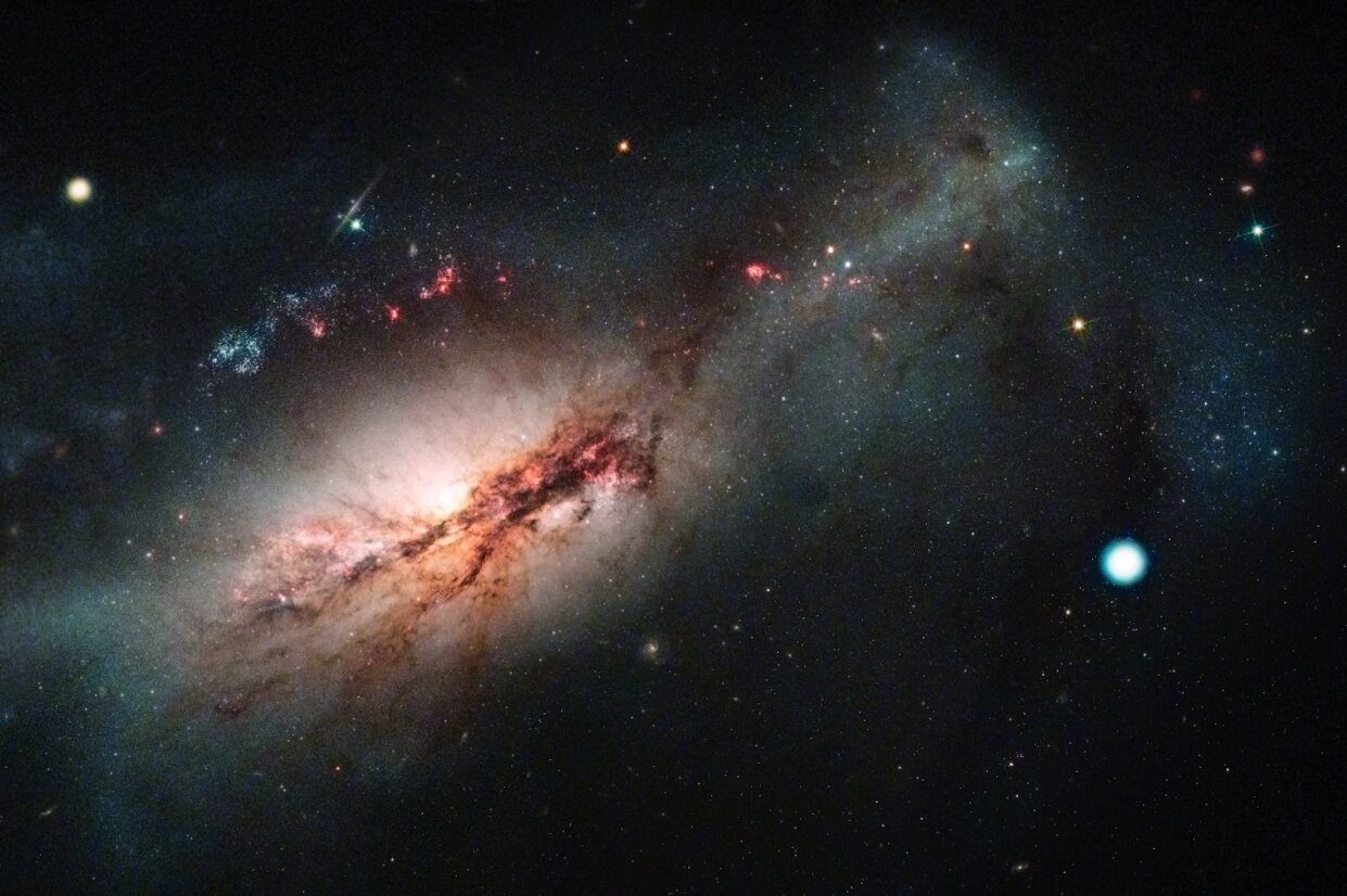 Acima, composição colorida da supernova de captura de elétrons 2018zd (o grande ponto branco à direita) e a sua galáxia hospedeira, a NGC 2146 (à esquerda). (Foto: NASA / STSCI / J. Depasquale; Observatório Las Cumbres)