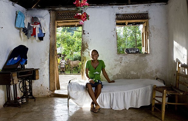 Altidon, 19 anos, de Maniche, no Haiti, quase não tem móveis. São apenas a cama, uma cadeira e uma antiga máquina de costura (Foto: Gabriele Galimberti )