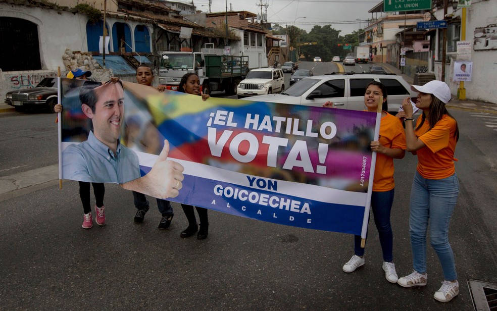 Eleitores do candidato de oposição Yon Goicoechea exibem faixa em Caracas, na quinta-feira (7), três dias antes de eleições municipais na Venezuela (Foto: AP Photo/Fernando Llano)