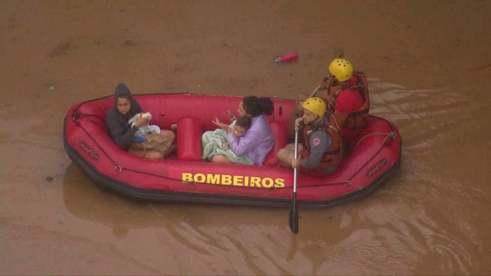 Criança é resgatada por bombeiros por bote em alagamento em São Paulo — Foto: Reprodução/TV Globo