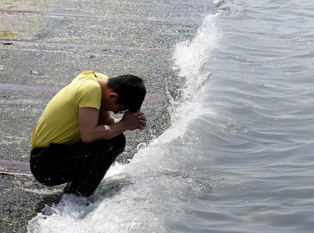 Homem faz orações por desaparecidos à beira do mar em Jindo (Foto: Kim Kyung-Hoon/Reuters)