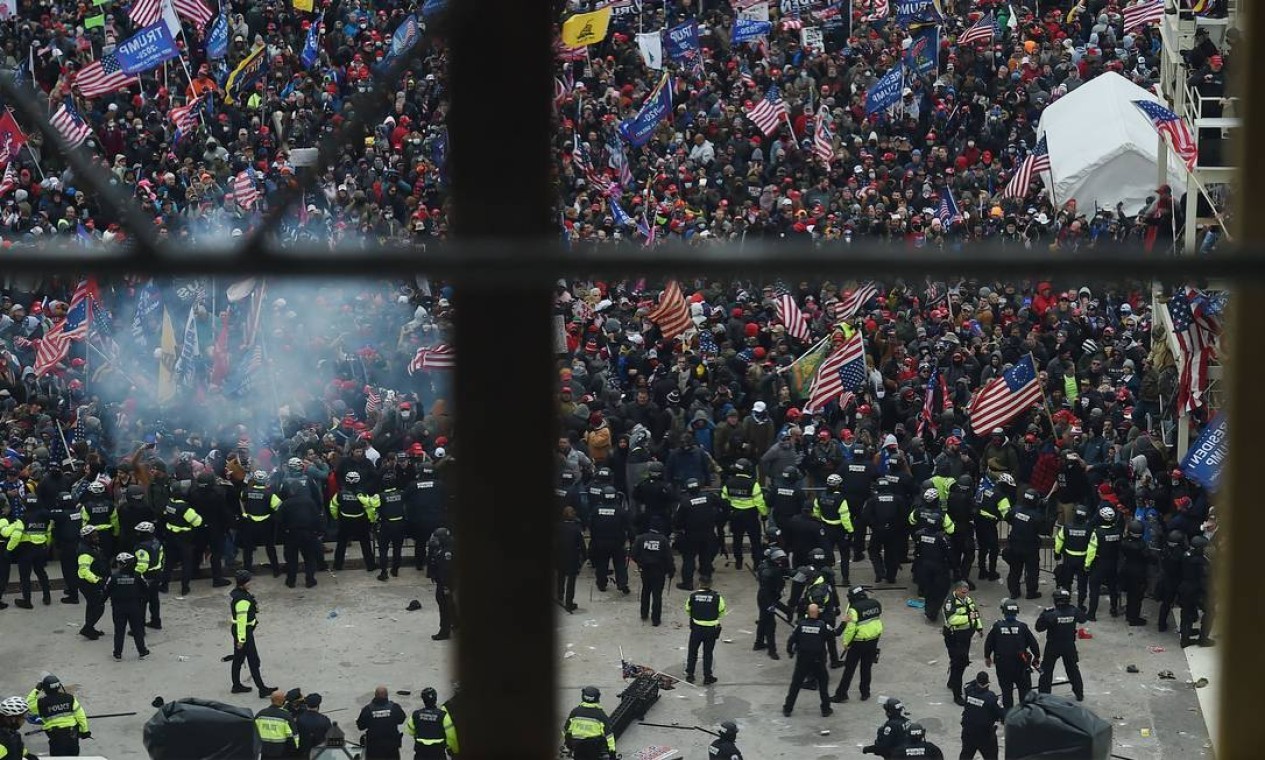 A polícia segura apoiadores do presidente dos EUA, Donald Trump, enquanto eles se reúnem em frente à Rotunda do Capitólio dos EUA — Foto: OLIVIER DOULIERY / AFP