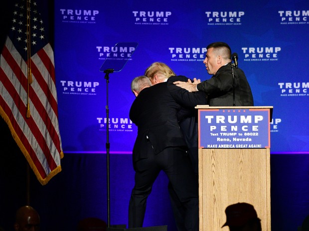 Donald Trump é retirado do palco por agentes durante comício em Nevada, nos EUA, neste sábado (5). (Foto: REUTERS/Steven Styles)
