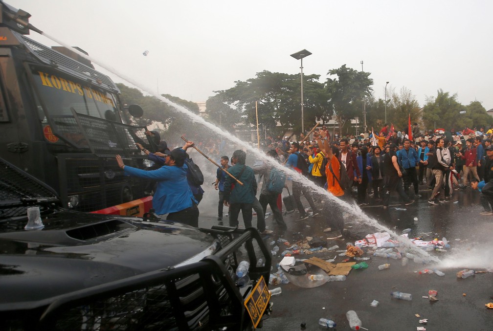 Manifestantes atacam um veículo da polícia durante o protesto de estudantes universitários fora do Parlamento da Indonésia, em Jacarta, na terça-feira (24) — Foto: Willy Kurniawan/ Reuters
