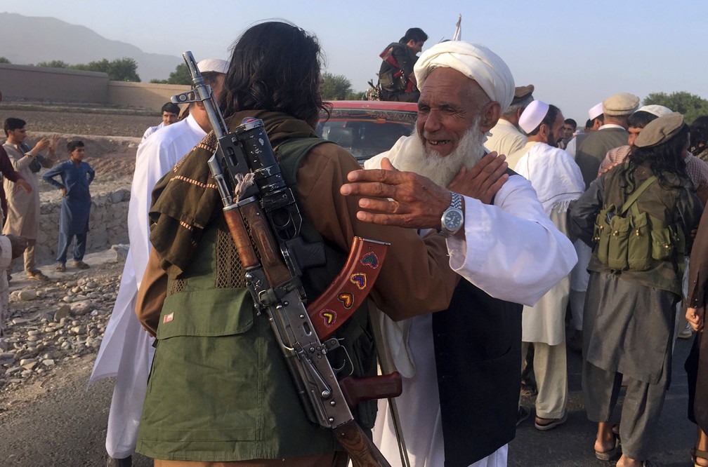 Foto de 16 de junho mostra combatentes talibãs comemorando com moradores locais a trégua de três dias, organizada por causa do feriado muçulmano do Eid al-Fitr, na província de Nangarhar  — Foto: Rahmat Gul/AP