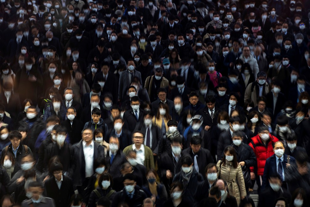 2 de março - Multidão caminha de máscaras em Tóquio durante a pandemia do coronavírus — Foto: REUTERS/Athit Perawongmetha