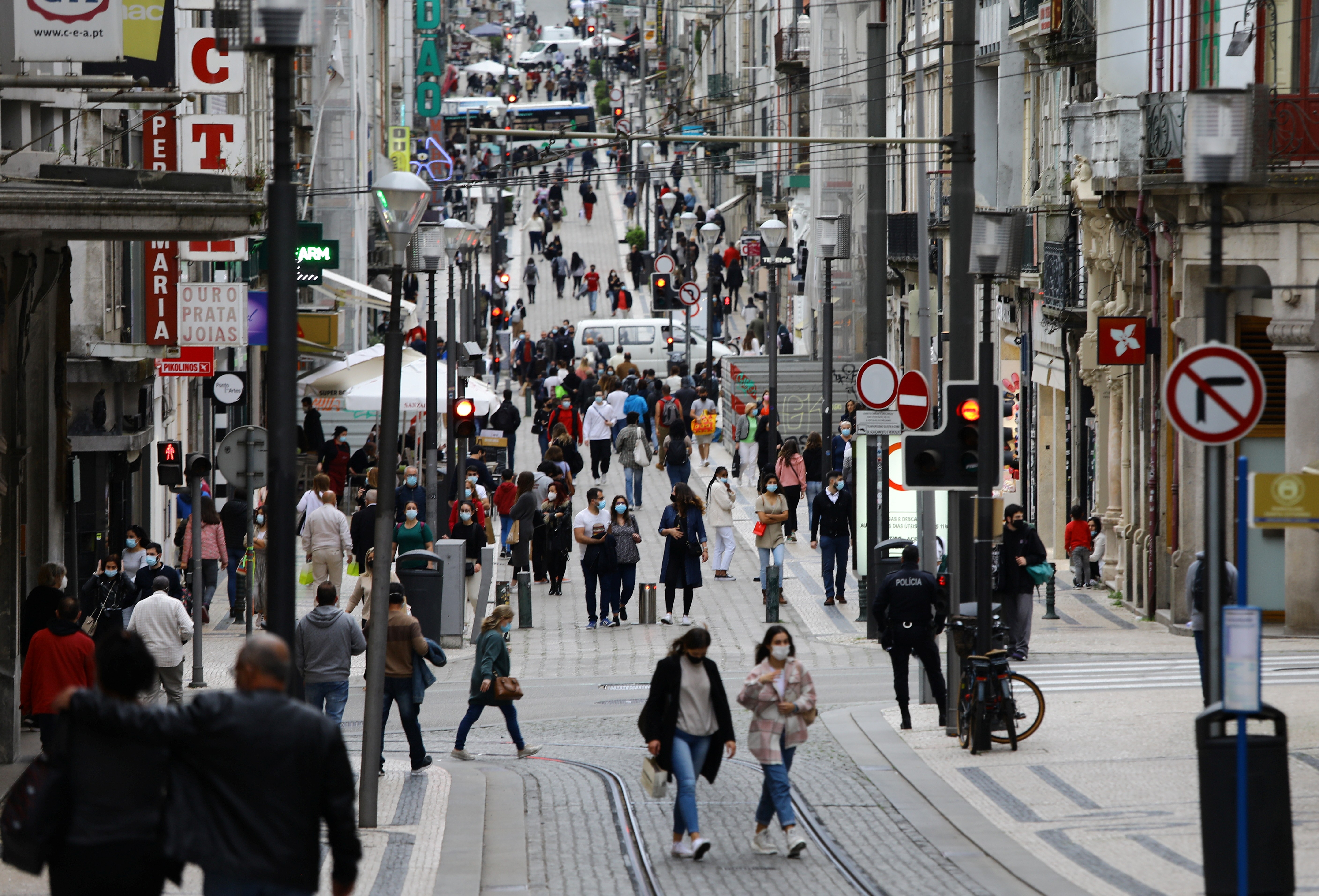 Pessoas caminham na Rua de Santa Catarina, no Porto, Portugal
