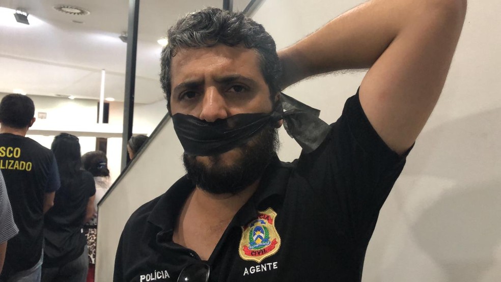 Com a boca tapada, agente de polícia faz protesto na Assembleia Legislativa — Foto: Heitor Moreira/TV Anhanguera