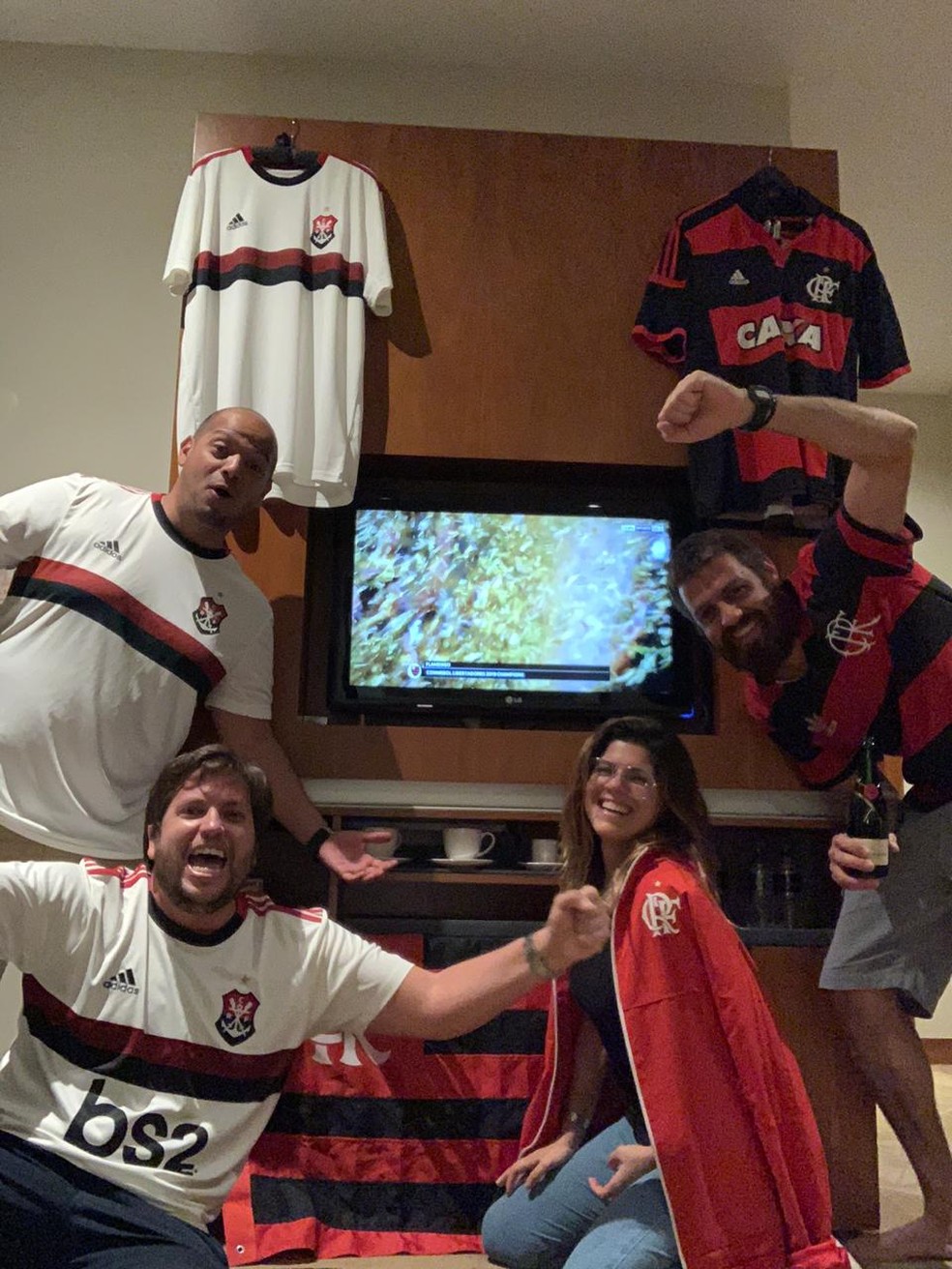 Quatro dos cinco integrantes da Fla Qatar festejam título da Libertadores no quarto ornamentado que serve para reunir em dias de jogos — Foto: Arquivo pessoal