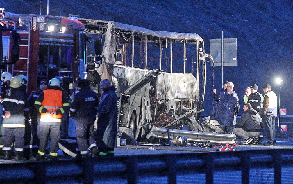 Funcionários trabalham no local do acidente de ônibus na Bulgária em que 45 pessoas morreram. Tragédia ocorreu em rodovia próxima ao vilarejo de Bosnek, ao sul da capital Sófia — Foto: Dimitar Kyosemarliev/AFP