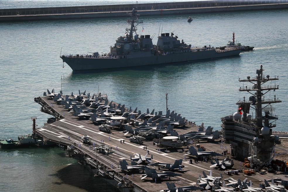 O porta-aviões nuclear americano e o destróier USS Barry Aegis (no alto): esquadra dos EUA participará de treinamentos militares com sul-coreanos — Foto: YONHAP / AFP
