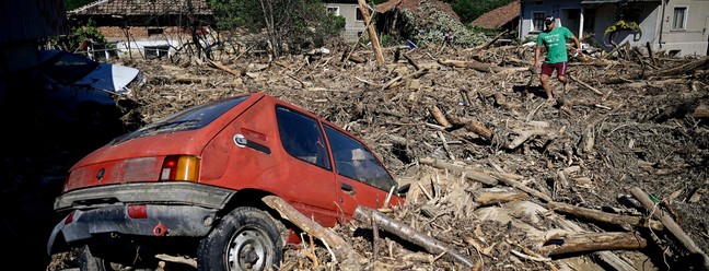 Carro é visto nos escombros na rua principal da vila de Slatina após uma forte inundação nas vilas de Slatina, Bogdan e Karavelovo, na Bulgária — Foto: NIKOLAY DOYCHINOV / AFP