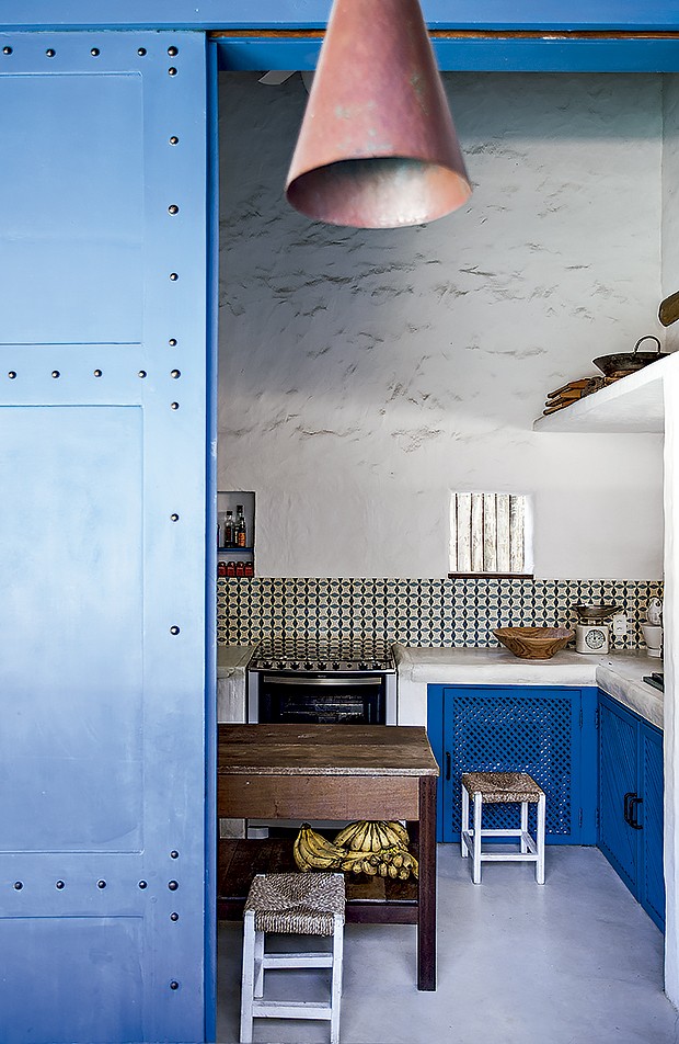 Na cozinha, os ladrilhos comprados em Arraial d’Ajuda foram inspirados nos tunisianos antigos. Mesa e banquinhos vieram de loja de móveis usados (Foto: Marco Antonio/ Editora Globo)