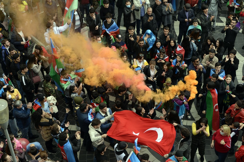 Azerbaijanos comemoram com bandeiras do país de Turquia em Baku, capital do Azerbaijão, nesta terça-feira (10), após assinatura de acordo com a Armênia — Foto: AP