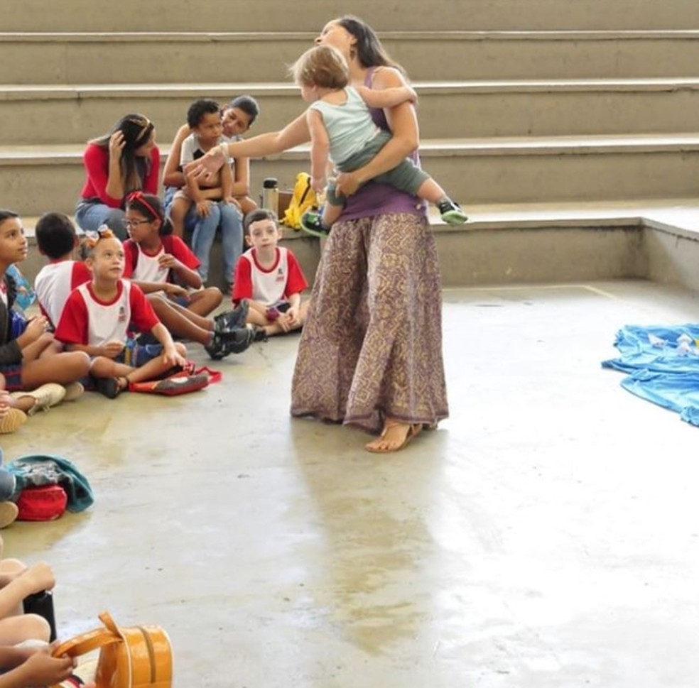 Manu Coutinho com o filho no braço ao contar histórias para crianças da Paraíba (foto antes da pandemia) — Foto: Manu Coutinho/Arquivo pessoal