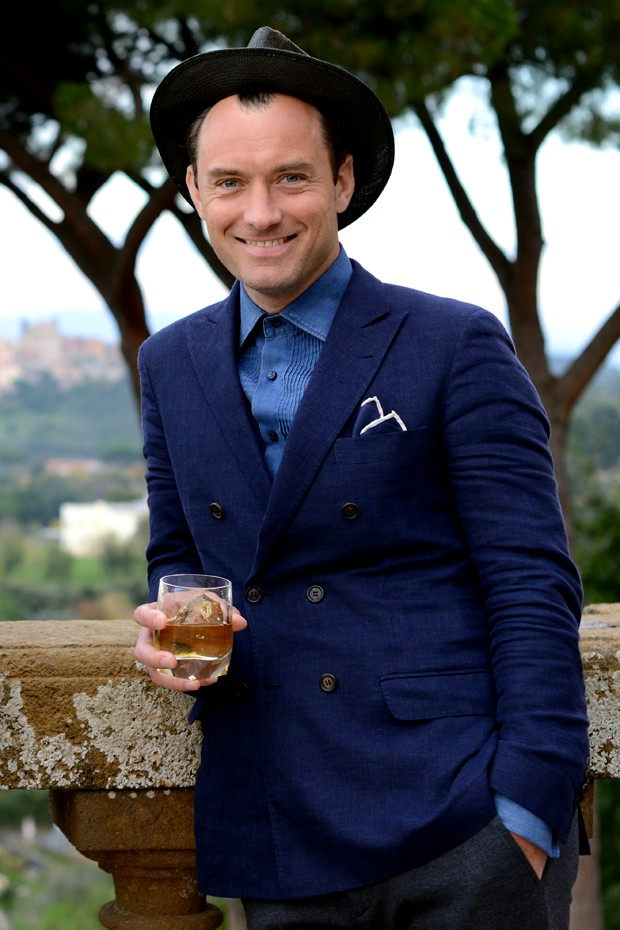 Jude Law: resultado cool com blazer de abotoamento cruzado, camisa fechada e chapéu (Foto: Getty Images)