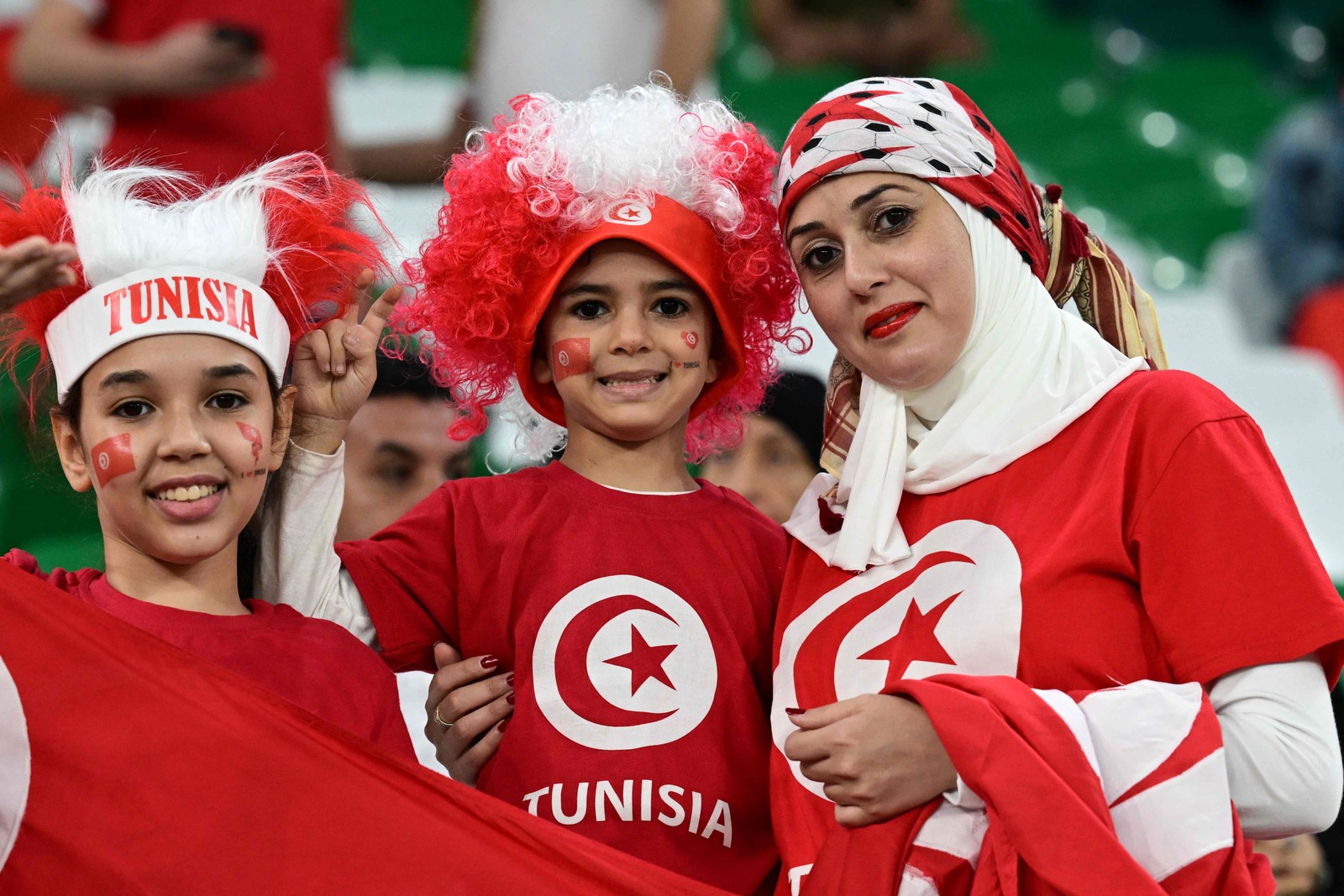 Família torce junto para a Tunísia contra a França na última rodada da fase de grupos da Copa do Catar — Foto: MIGUEL MEDINA/AFP