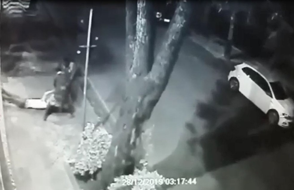 Homem é arrastado por dois suspeitos na calçada, em BH — Foto: Reprodução/TV Globo