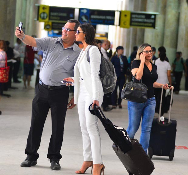 Ao desembarcar no aeroporto Santos Dumont, no Rio, atriz posou para selfie com fã (Foto: AgNews)