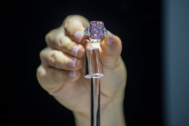 A woman holds the Sakura Diamond during preview at Christie's in Hong Kong, China, 20 May 2021. The 15.81 Carat Fancy Vivid Purple Pink Internally Flawless Type lla Diamond Ring will be auctioned in Hong Kong on 23 May 2021 for an estimated 25 million to  (Foto: NurPhoto via Getty Images)