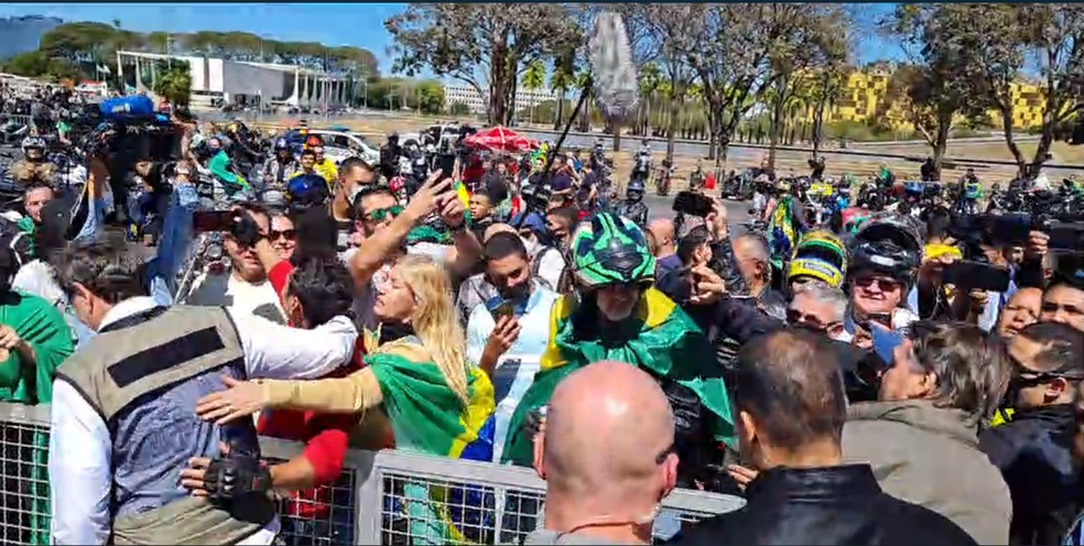 Ao final do passeio de moto, Bolsonaro posou para fotos com apoiadores, novamente aglomerados e sem máscara — Foto: Reprodução/Facebook