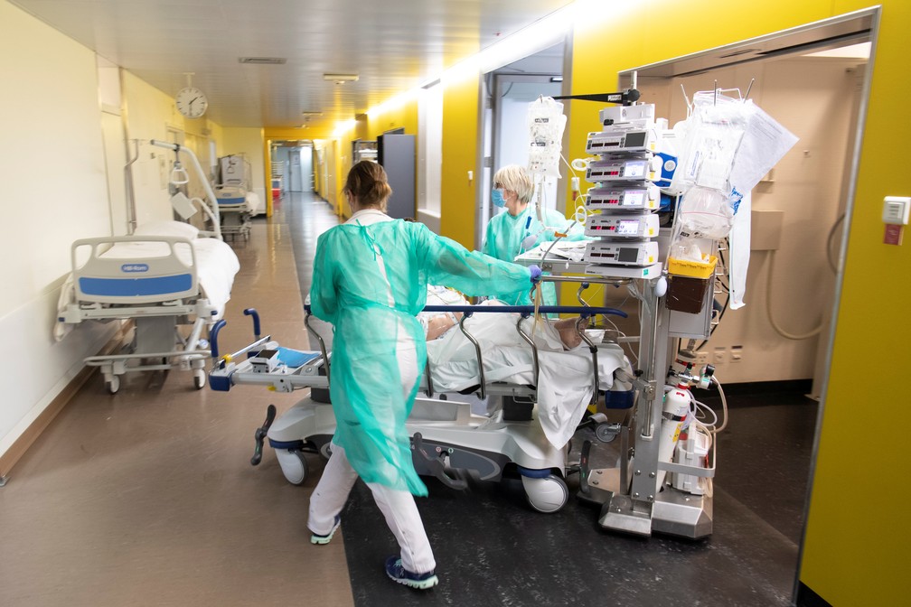31 de março: Profissionais de saúde empurram maca de paciente em Lausanne, na Suíça, em meio à pandemia de Covid-19. — Foto: Laurent Gillieron/Pool via Reuters