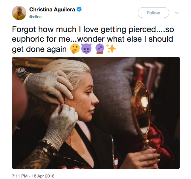 A cantora Christina Aguilera sem maquiagem colocando um piercing (Foto: Twitter)