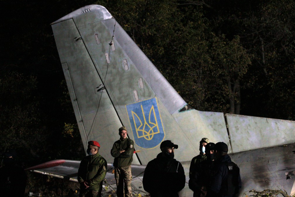 Soldados guardam destroços de aeronave militar que caiu na Ucrânia nesta sexta (25) — Foto: Sergey Bobok/AFP