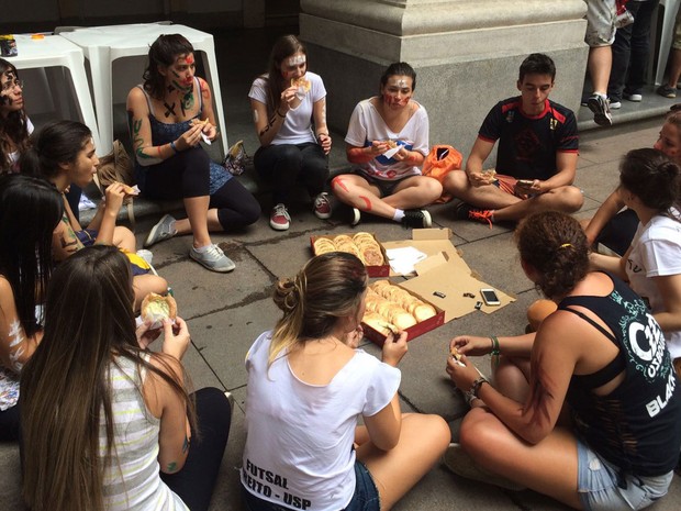 Novos alunos da faculdade de direito da USP comem esfihas após pedágio no Centro de São Paulo. (Foto: Vanessa Fajardo/G1)