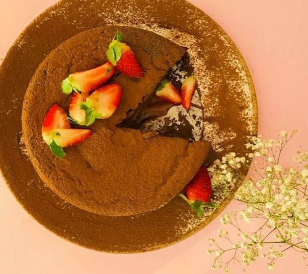 Decore o bolo vulcão vegano de chocolate com morangos fatiados (Foto: Reprodução / Instagram)