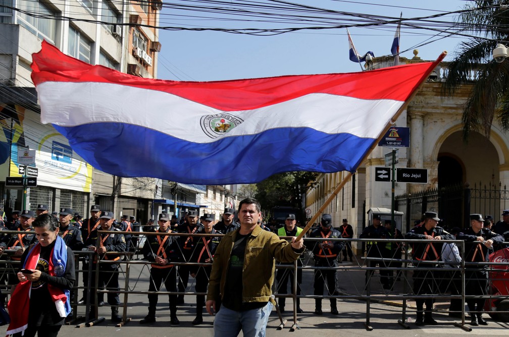 Manifestante agita bandeira do Paraguai em protesto em Assunção contra o presidente Mario Abdo — Foto: Jorge Adorno/Reuters