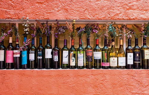 Apaixonado por gastronomia, Eduardo Martins coleciona garrafas de vinho. Com rótulo, elas viram vasos cheios de história