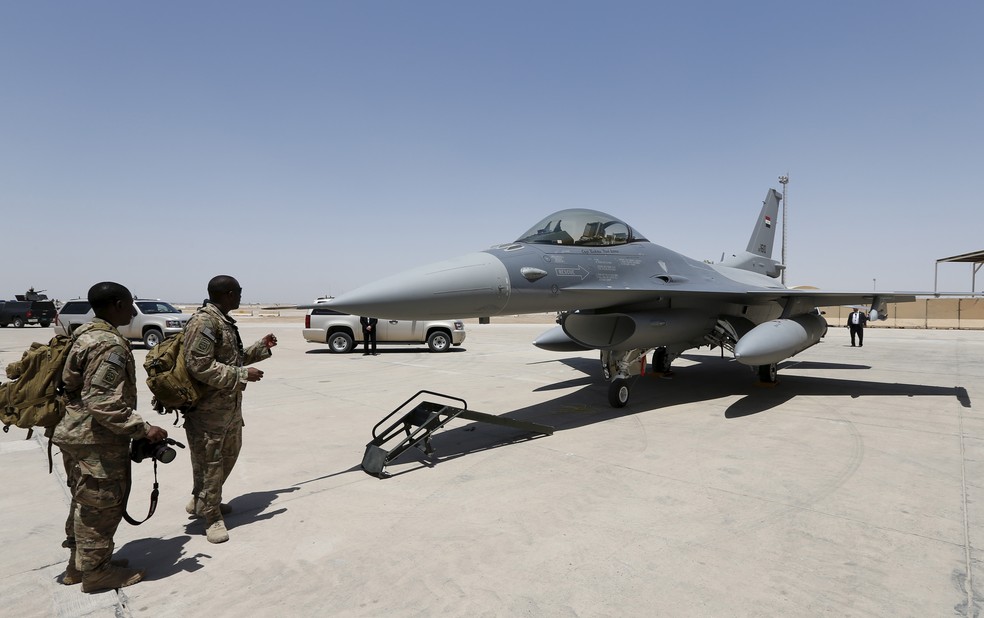 Militares norte-americanos obsevam jato F-16 na base em Balad — Foto: Reuters