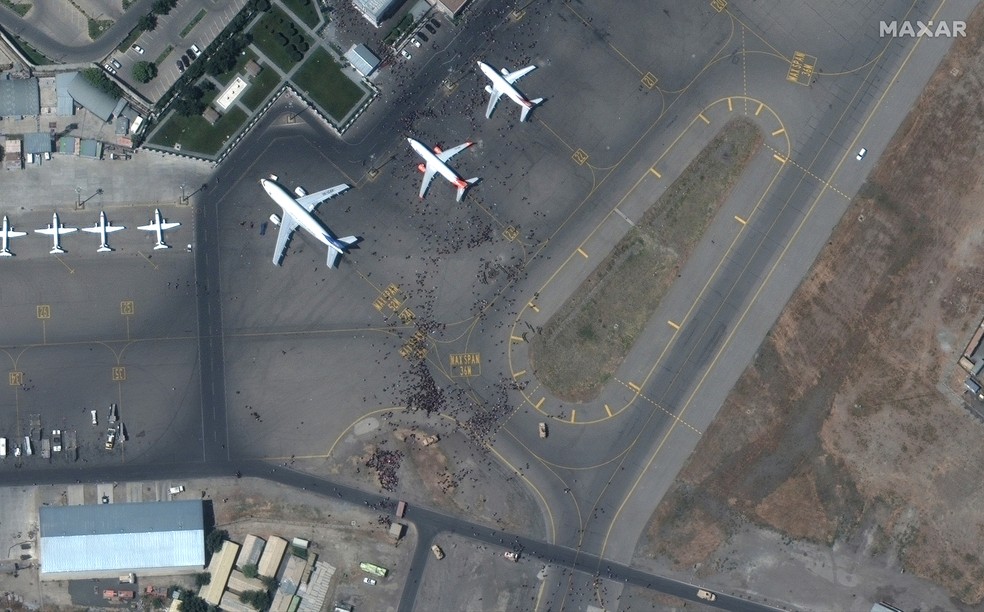 Imagem de satélite do dia 16 de agosto mostra pessoas na pista do Aeroporto Internacional de Cabul, capital do Afeganistão — Foto: Satellite Image 2021 Maxar Technologies via Reuters