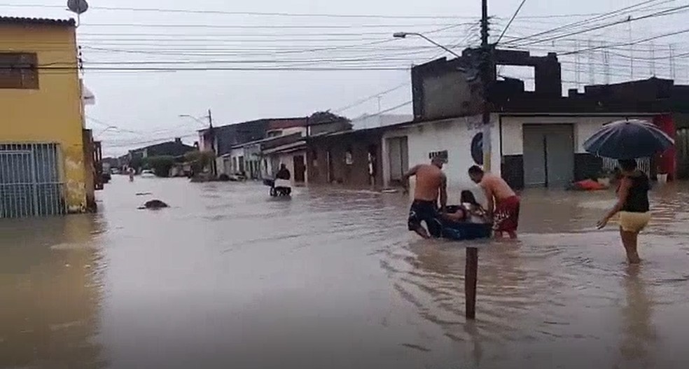 Moradores retiram vizinha com problemas de saúde de casa alagada — Foto: Arquivo pessoal