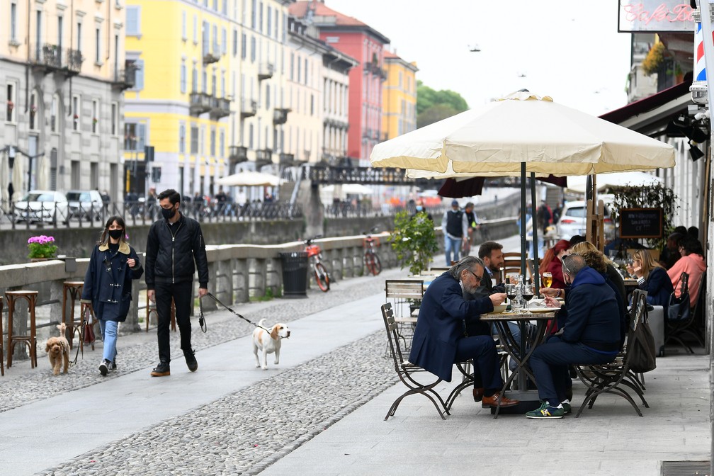 Pessoas almoçam ao ar livre em restaurante no canal Navigli, em Milão, no dia em que grande parte da Itália avança para a 'zona amarela' de restrições contra a Covid-19 nesta segunda (26) — Foto: Flavio Lo Scalzo/Reuters