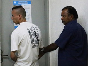 Edilson Almeida Silva (à esq.) é levado para carceragem (Foto: Alex Falcão/Futura Press/Estadão Conteúdo)