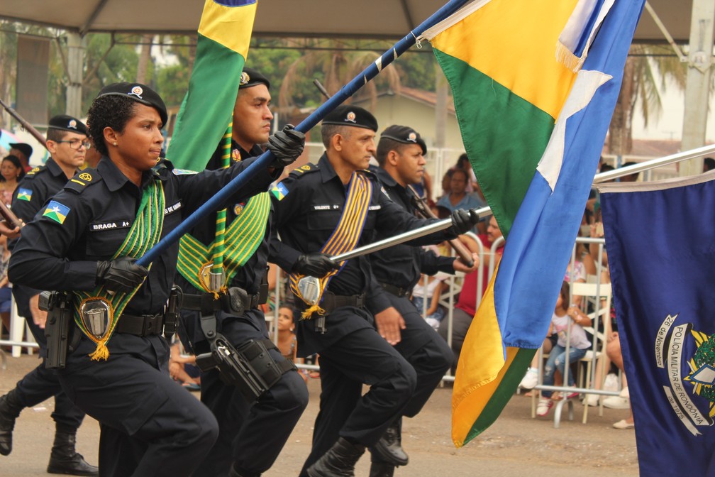 Policial segura bandeira durante desfile militar em Porto Velho. (Foto: Pedro Bentes/G1)