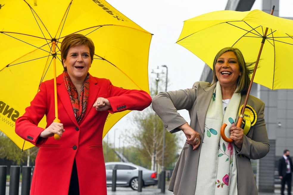 Nicola Sturgeon (à esquerda, de vermelho) parabeniza a candidata SNP Kaukab Stewart, que foi eleita integrante do Parlamento Escocês nas eleições legislativas escocesas de 8 de maio 2023. — Foto: Andy Buchanan / AFP