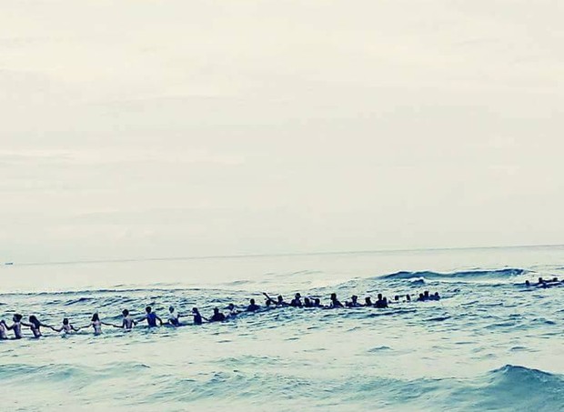Corrente humana formada por banhistas tentando alcançar família que se afogava (Foto: Facebook)