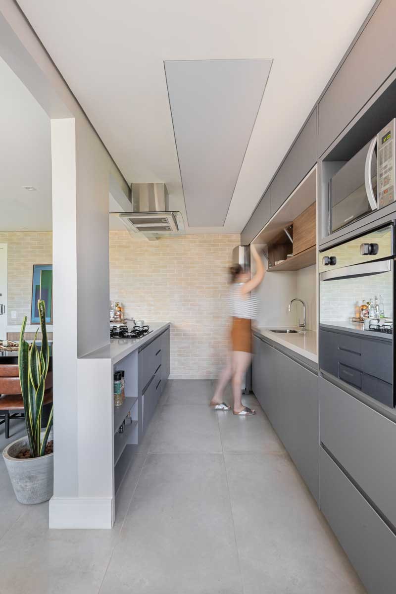 COZINHA | Com desenho do escritório Guel Arquitetos, os armários são de MDF revestido de Duratex Cinza e Carvalho Hanover. O nicho da pia é de quartzo branco  (Foto: Júlia Tótoli / Divulgação)