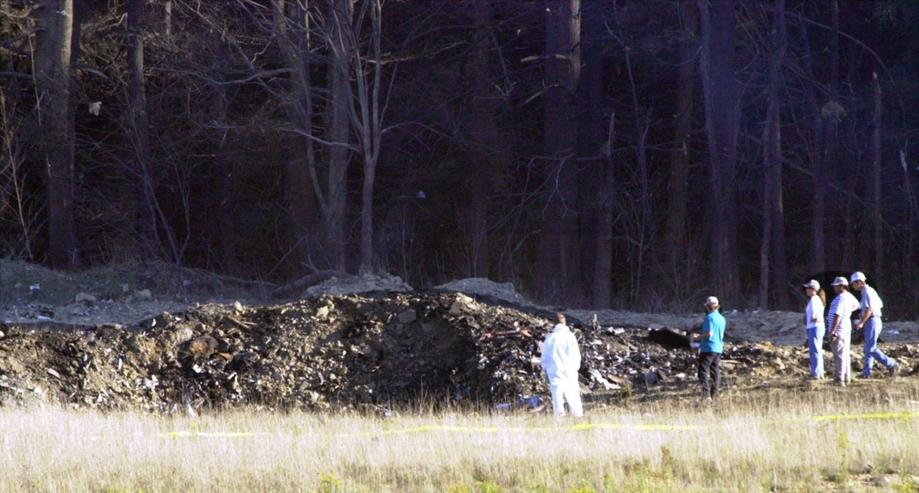 Equipe de emergência trabalha no local da queda do voo 93 da United Airlines em Shanksville, na Pensilvânia. Passageiros lutaram contra os terroristas, e o avião foi jogado no solo a 20 minutos da capital — Foto: Keith Srakocic/AP/Arquivo