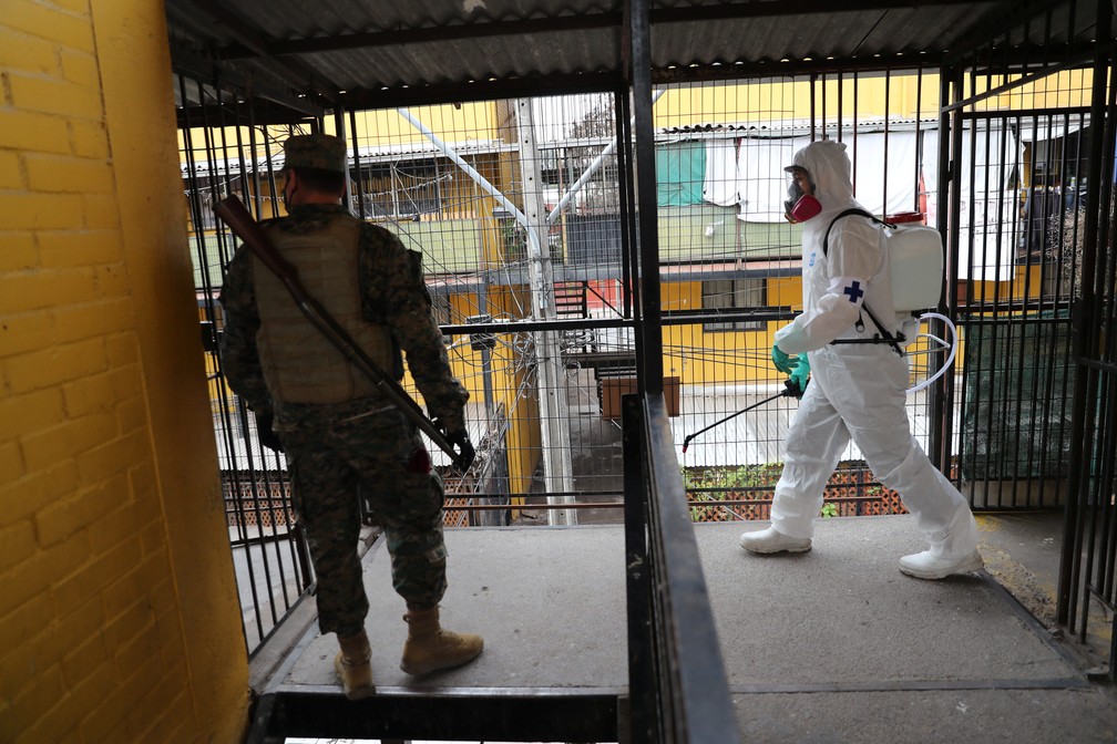 Militar observa trabalhador desinfetar um imóvel em Santiago, no Chile, em 16 de junho de 2020 — Foto: Ivan Alvarado/Reuters
