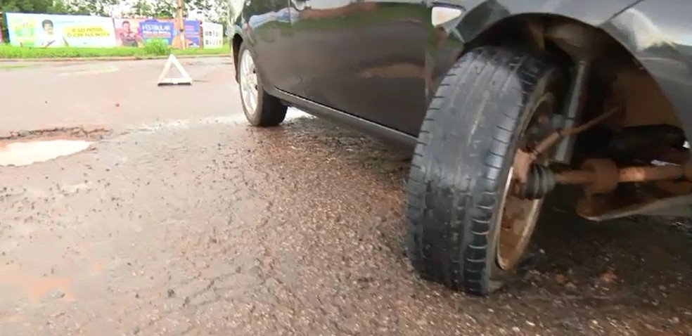 Carro ficou com a roda quebrada após cair em buraco na Rodovia AC-40, em Rio Branco (Foto: Reprodução/Rede Amazônica Acre)