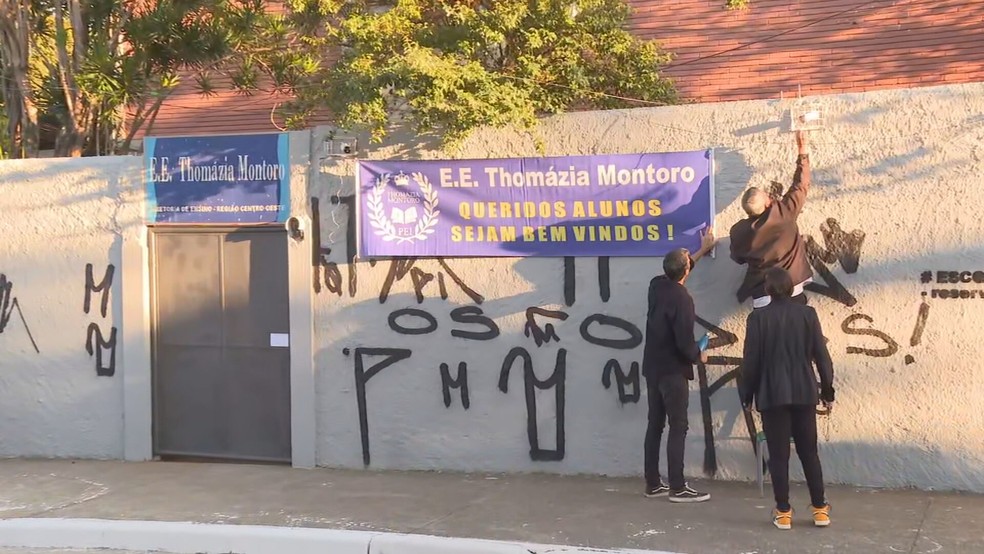 Cartaz é colocado no muro da escola para receber grupo de alunos  — Foto: Reprodução/TV Globo