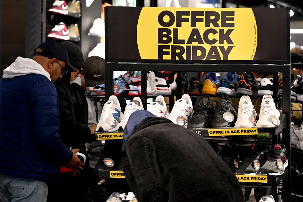 Consumidores avaliam descontos oferecidos durante a Black Friday em Paris, na França. — Foto: Emmanuel Dunand / AFP