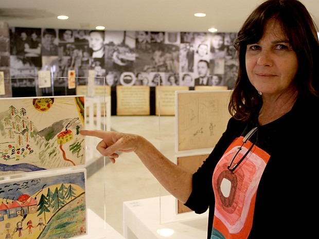 Karen Zolko, uma das curadoras da mostra, ao lado de desenhos (Foto: Vianey Bentes/TV Globo)